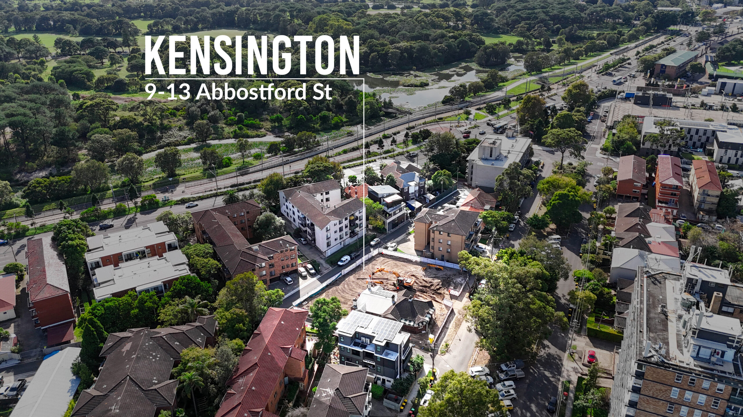 Aerial view of a construction site at 9-13 Abbotsford St, Kensington featuring a heritage-listed building on site and yellow excavators at work, delivered by MESO Solutions.